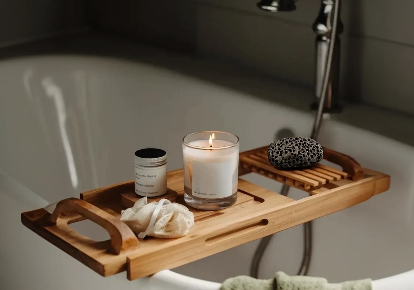 Badewanne mit Holzbrett, Kerze, Creme und Badetuch für Wellness-Moment